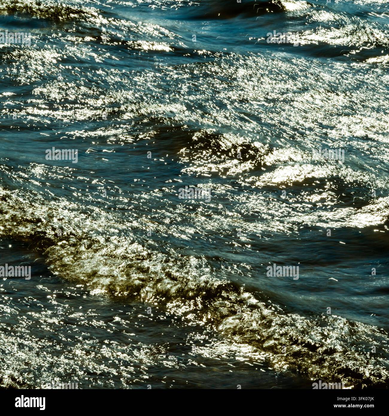 La luce intensa brilla sulle onde increspate Foto Stock