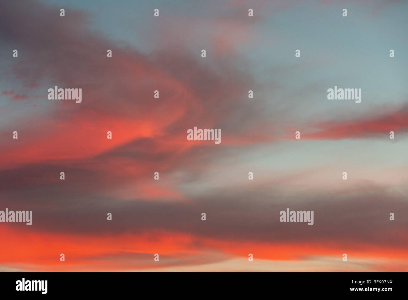 Cielo colorato al tramonto con nuvole arancioni e grigie Foto Stock