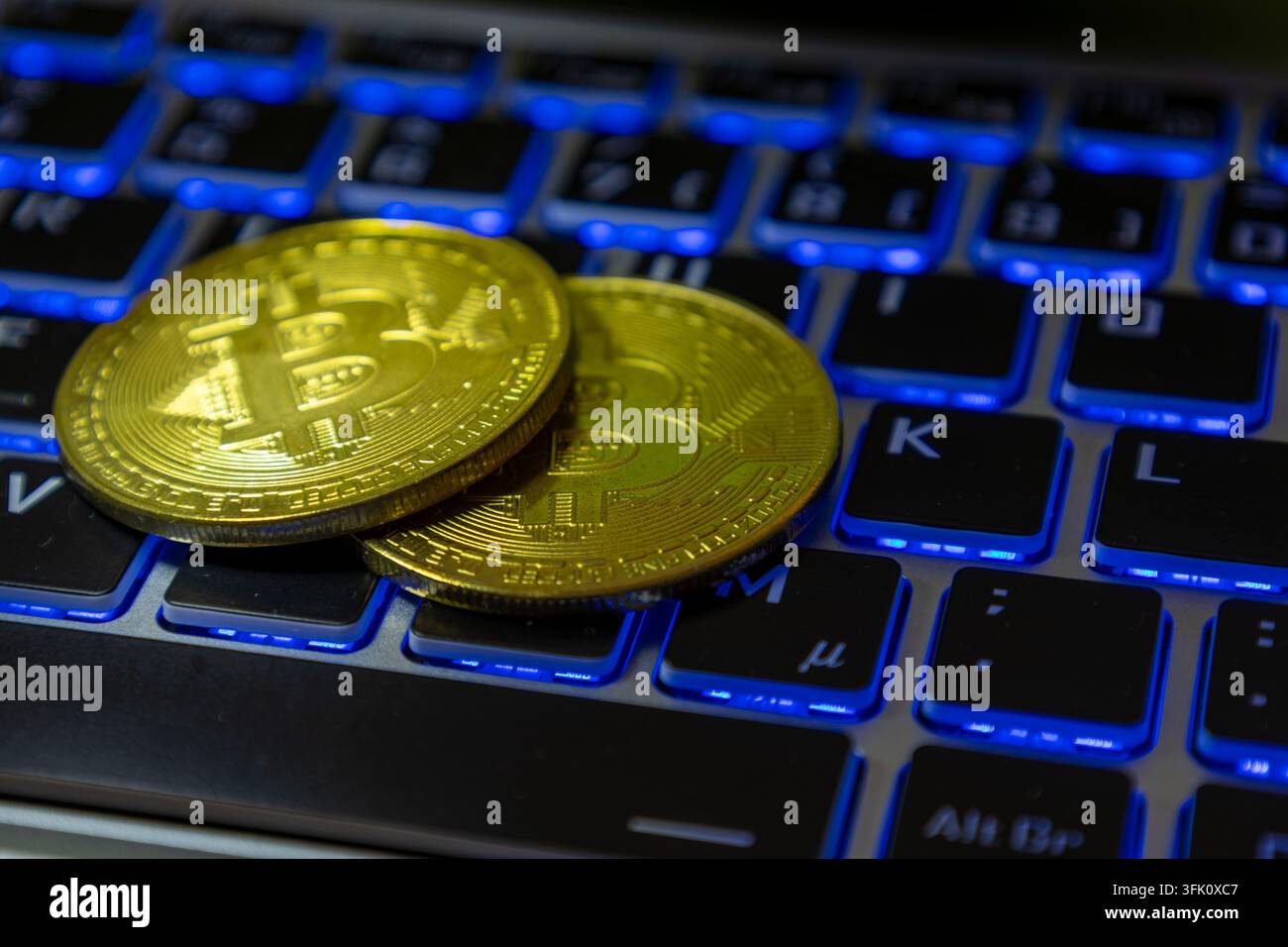 Primo piano di Bitcoin simbolici su una tastiera di laptop Foto Stock