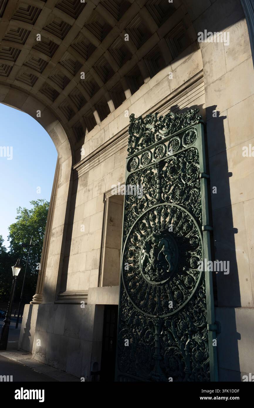 La luce del sole evidenzia il cancello verde ornato e la muratura dell'Arco di Wellington a Londra, mostrando il design intricato del monumento storico. Foto Stock