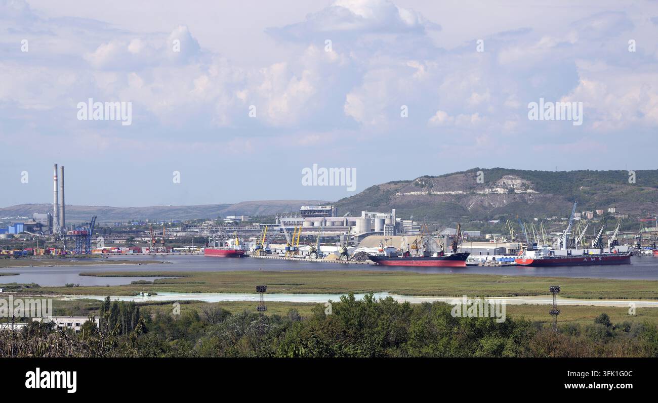 Operazioni portuali commerciali frenetiche con strutture industriali, gru e navi che trasportano commercio internazionale e logistica. Bulgaria, Devnya 21 Foto Stock