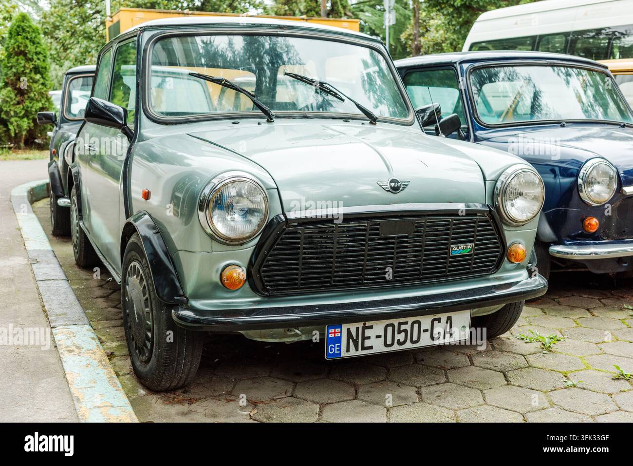 BATUMI, GEORGIA - 4 SETTEMBRE 2026: Austin Mini classico parcheggiato con altri veicoli d'epoca, vista tre quarti anteriore che mostra il design automobilistico britannico retrò. Foto Stock