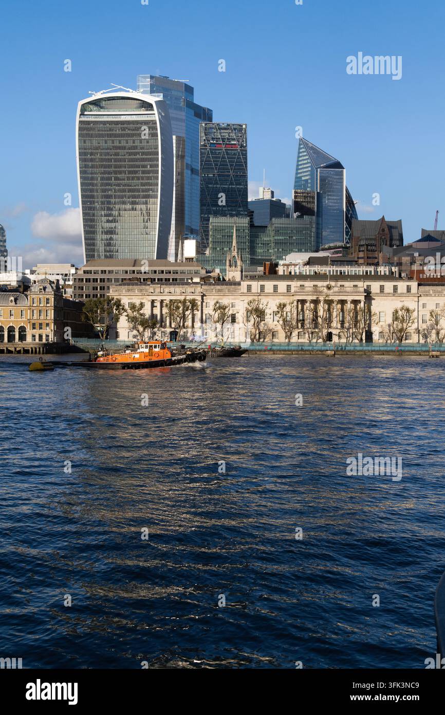 GPS il rimorchiatore di Cervia naviga sul Tamigi nella City di Londra, passando per la storica Custom House sotto l'iconico skyline finanziario. Foto Stock