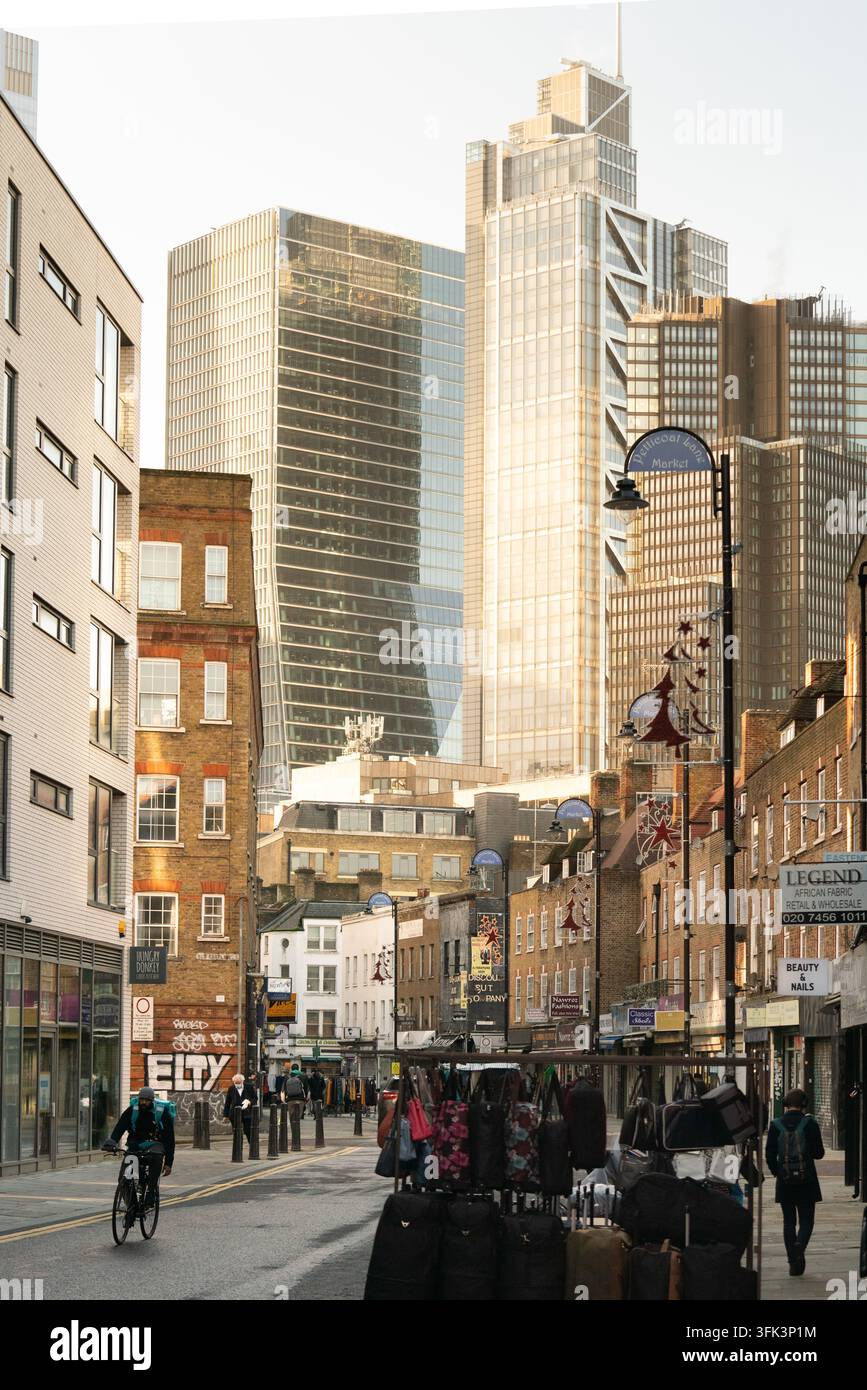 Gli amanti dello shopping e dei ciclisti navigano nello storico mercato di Petticoat Lane di Aldgate, contrastando il fascino del vecchio mondo di Londra con i moderni grattacieli. Foto Stock