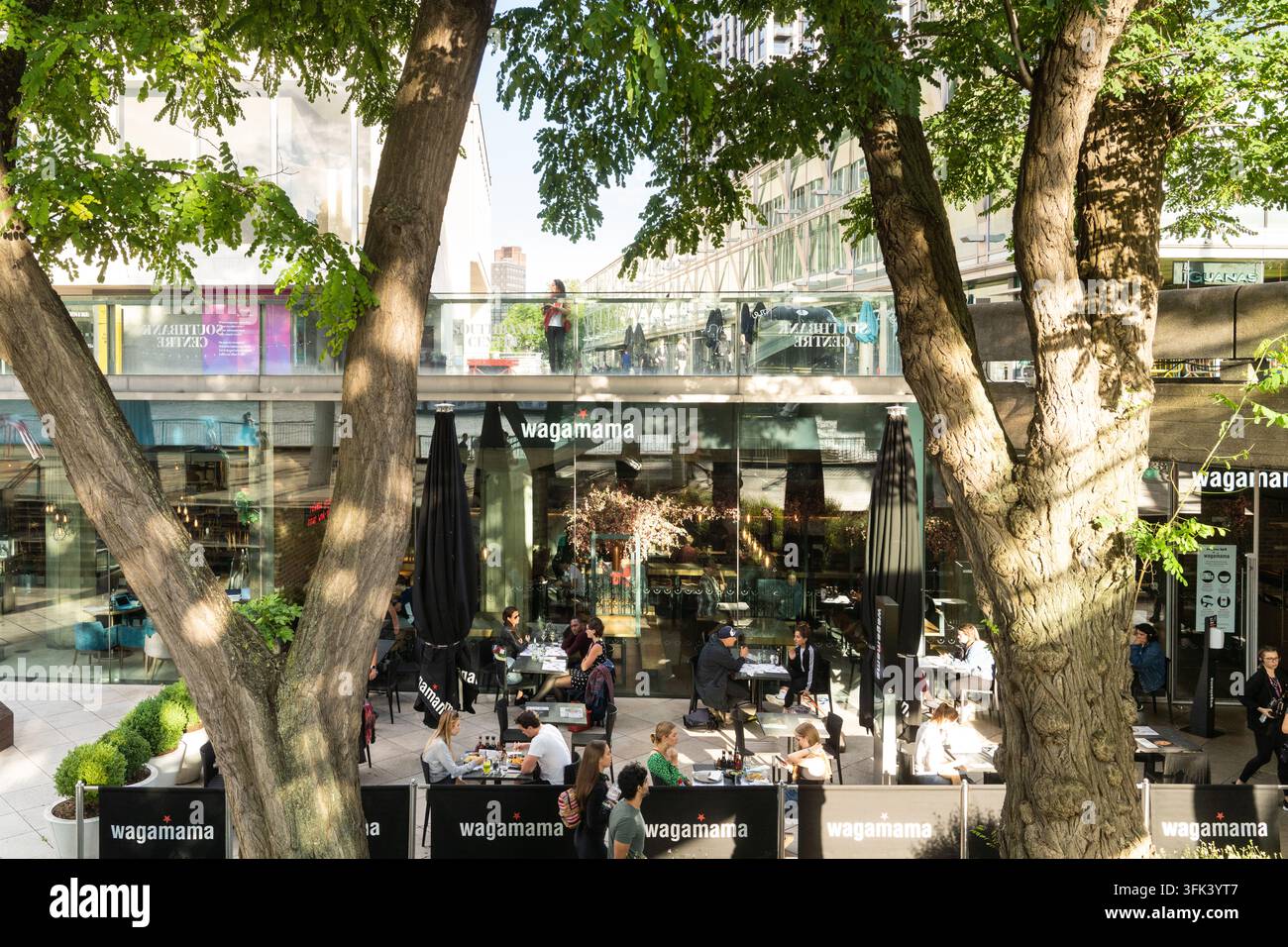 I clienti godono di un pasto all'aperto al Wagamama, situato nell'iconica Royal Festival Hall nel Southbank Centre di Londra. Foto Stock