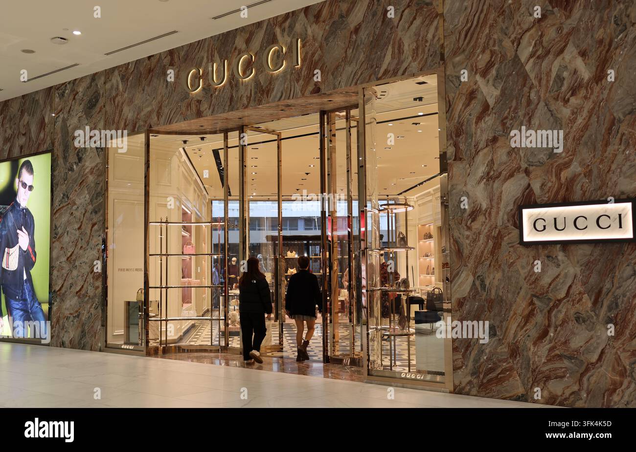 La lussuosa facciata in marmo e l'ingresso di una boutique di moda Gucci situata all'interno di un complesso commerciale di alta gamma Foto Stock