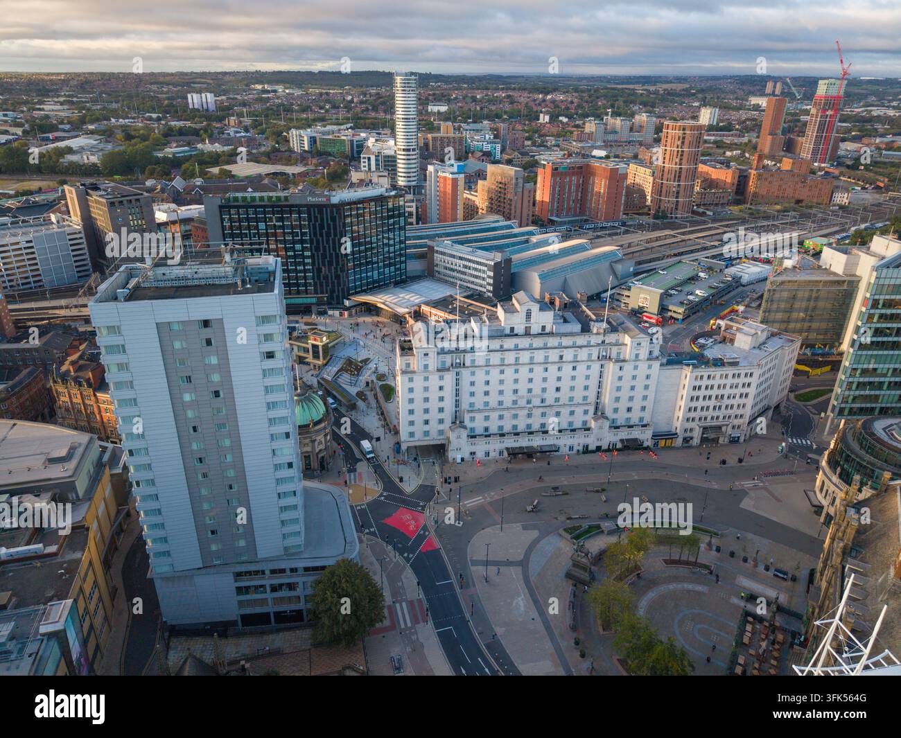 Immagine aerea su Leeds City Square e la stazione ferroviaria, che si estende verso lo skyline urbano moderno e l'orizzonte sotto le nuvole del mattino Foto Stock