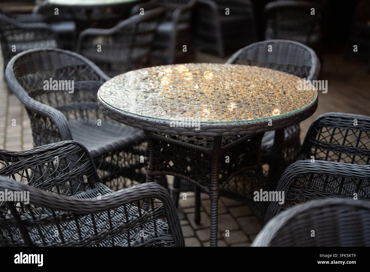 Terrazza all'aperto del caffè vuota con tavoli e sedie bagnati dopo la pioggia autunnale durante il periodo di bassa stagione Foto Stock