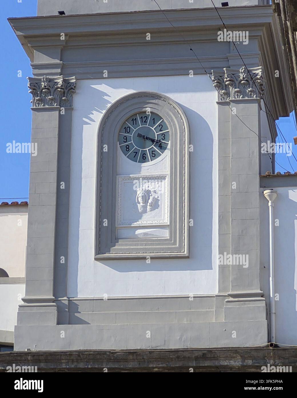 Un primo piano architettonico alla luce del giorno della sezione del campanile storico con un quadrante dell'orologio al Santuario della Madonna dell'Arco. - Immagine stock catturata con smartphone
