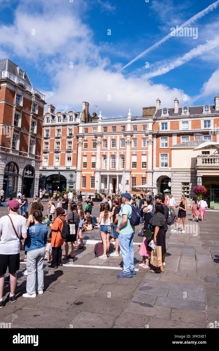 Inghilterra, Londra, Covent Garden: edifici in King Street e turisti che osservano una rappresentazione di strada Foto Stock