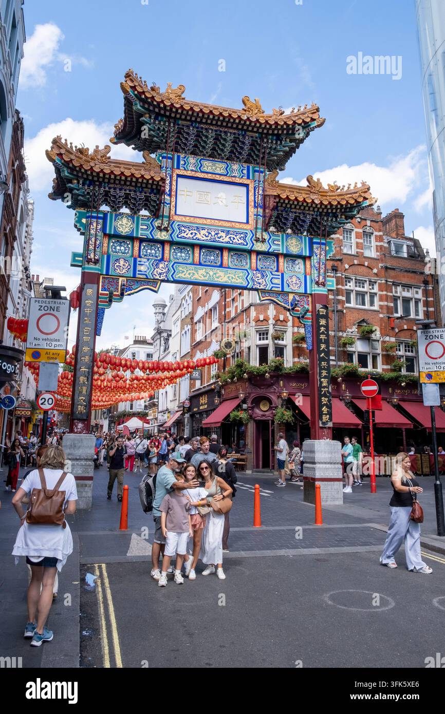 Inghilterra, Londra, Chinatown: turisti nel quartiere cinese che scattano foto davanti all'arco pagoda di Wardour Street Foto Stock
