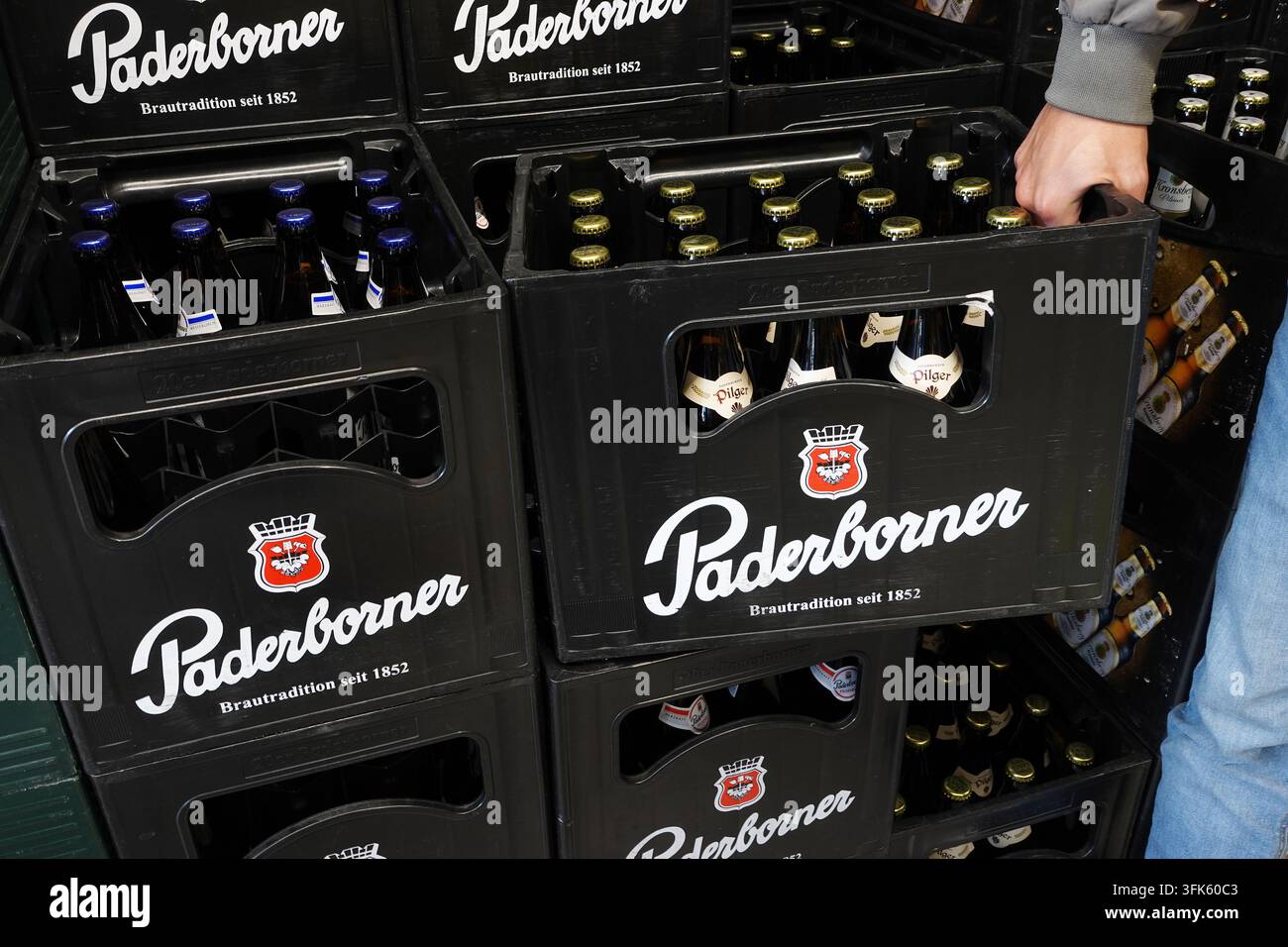 Una mano prende una cassa di birra Padeborner in un negozio Foto Stock