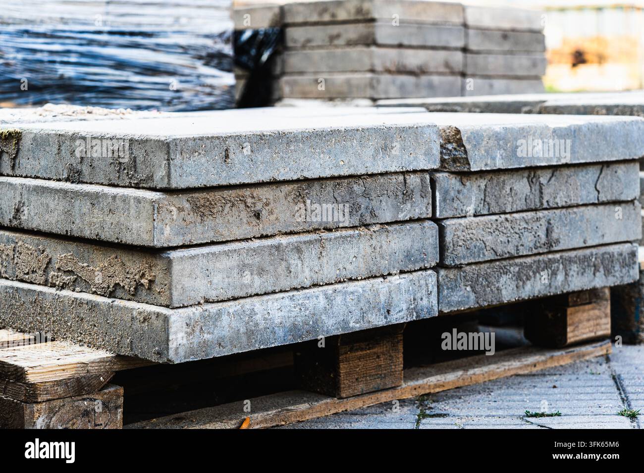 Piastre di pavimentazione in cemento impilate su pallet di legno pronte per l'installazione di vialetti e patii Foto Stock