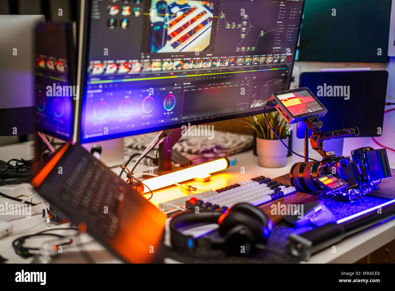 Spazio di lavoro professionale per l'editing video e il color grading con una configurazione multi-monitor che esegue software di post-produzione basato su nodi. La scrivania è dotata Foto Stock