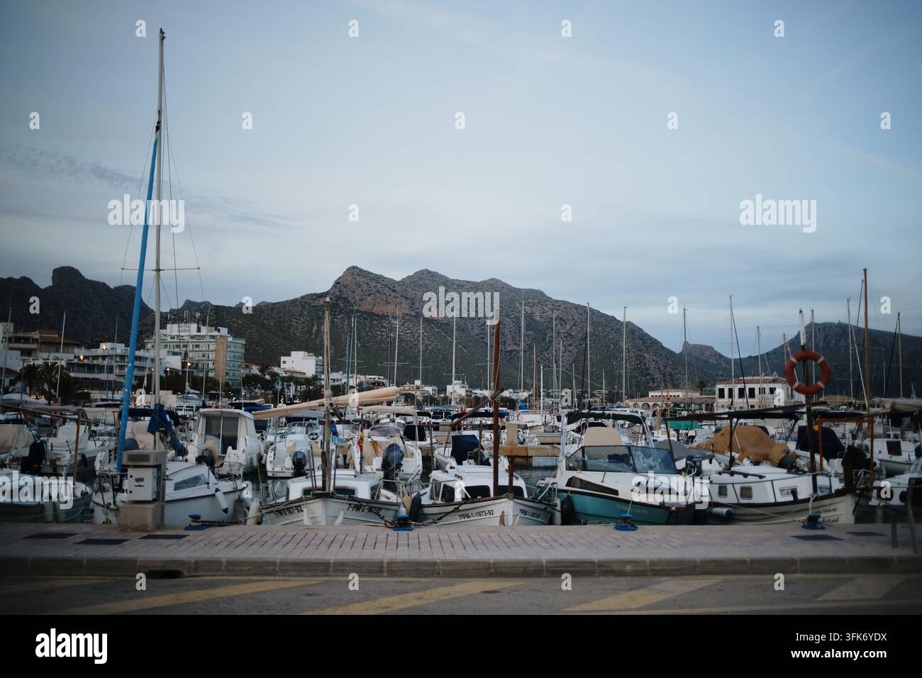 Port de Pollenca, Isole Baleari, Spagna - 05 gennaio 2025: Vista di un porto turistico pieno di barche e yacht, sullo sfondo montagne frastagliate u Foto Stock