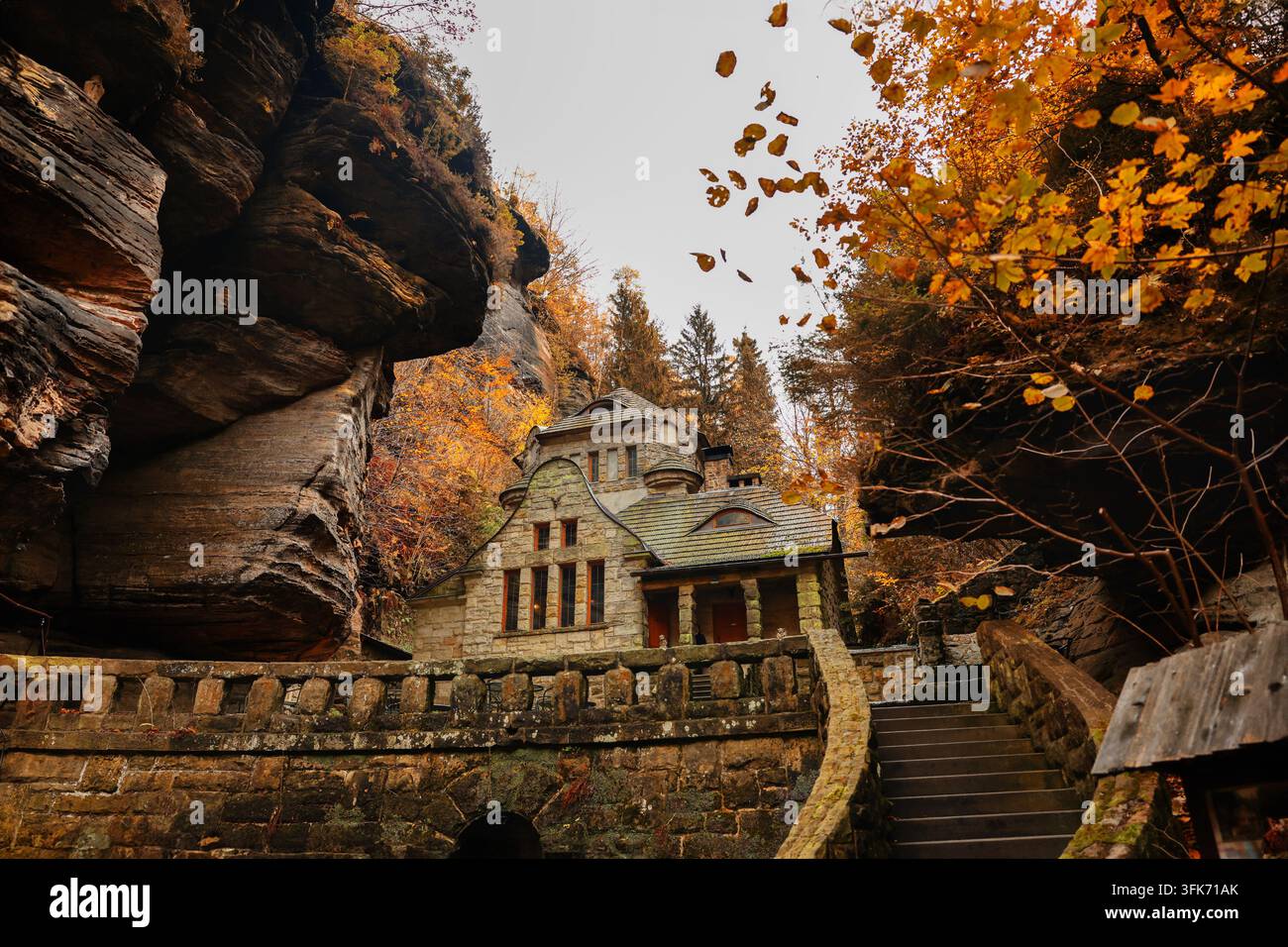 Sauria nascosto vicino a una casa di pietra in un canyon autunnale, che illustra la scoperta della fauna selvatica, il camuffamento e l'armonia con la natura. Foto Stock