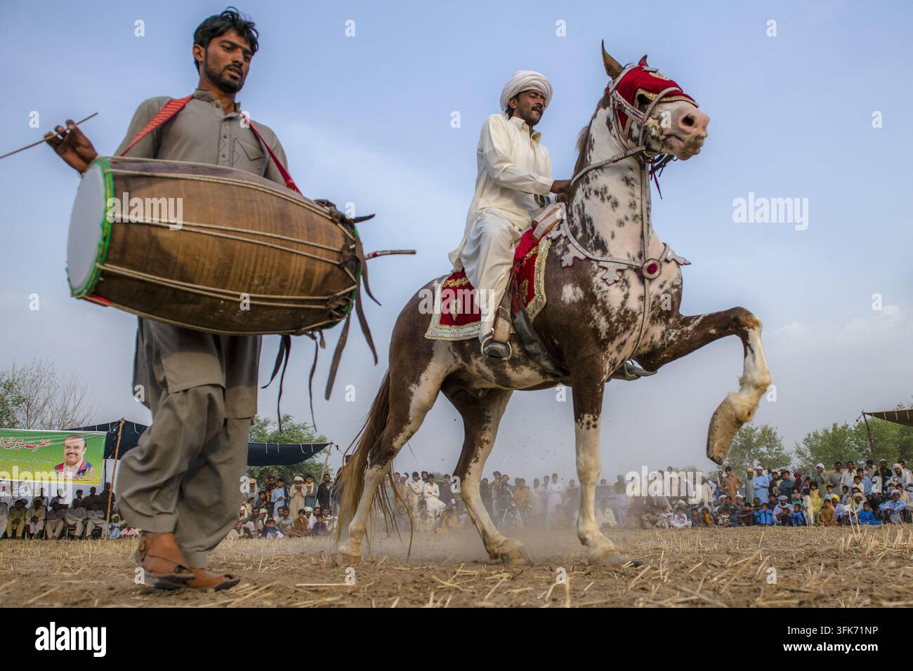 Bahawalpur, Punjab, Pakistan - 25 marzo 2025: Vista di un uomo che cavalca un cavallo decorato e interpreta una tradizionale danza Ghora Nach al ritmo di battiti o Foto Stock