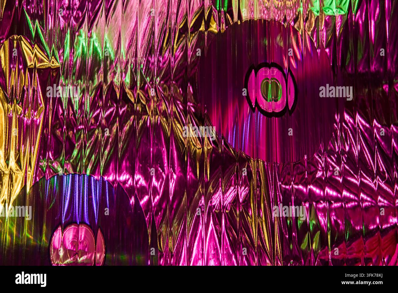 Modello luminoso colorato astratto con riflessi rosa, dorati e blu luminosi, effetti ottici e forme geometriche su uno sfondo strutturato. Foto Stock