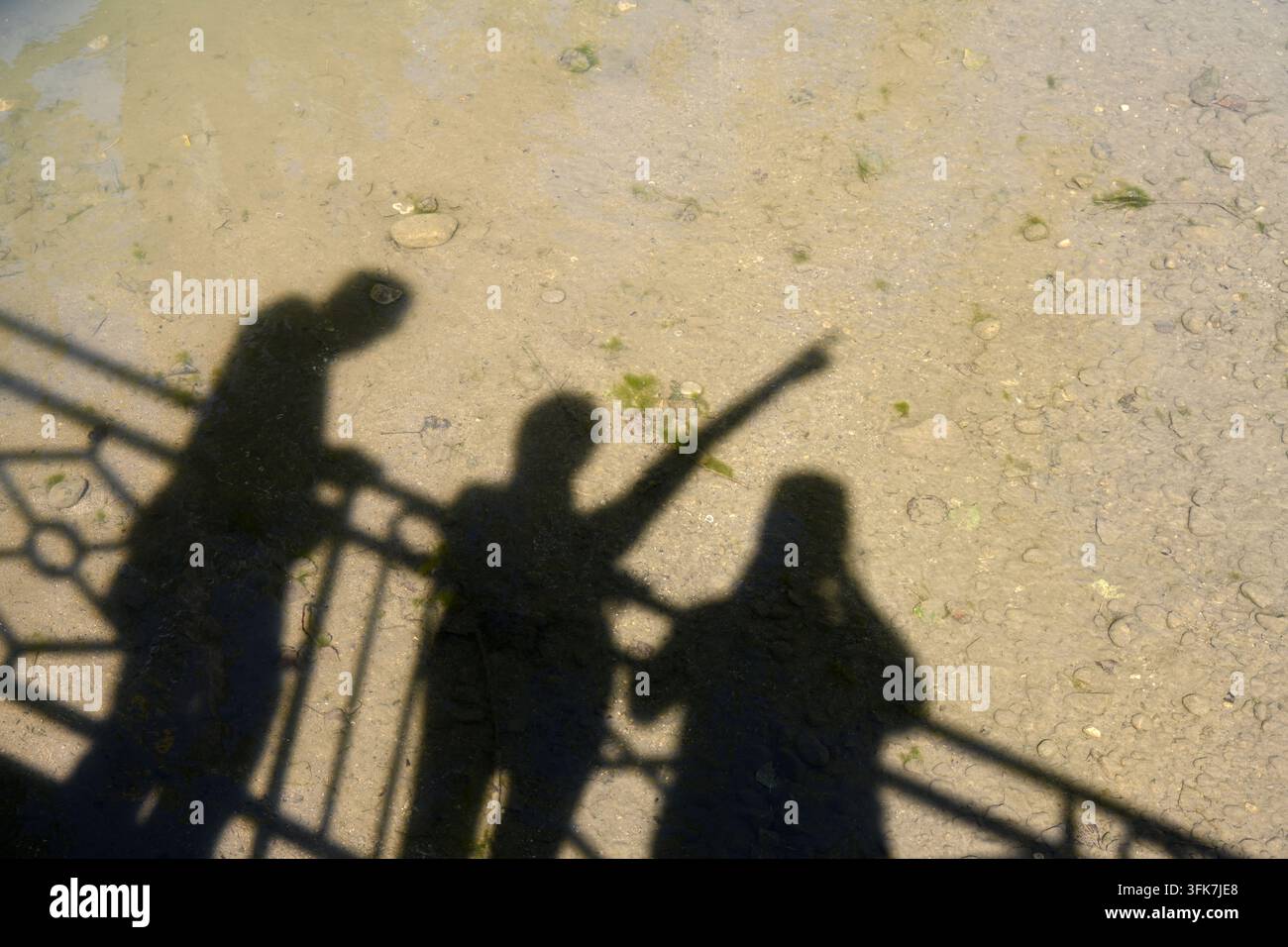 Ombre o Ombre di tre persone con la figura centrale che punta in lontananza Foto Stock