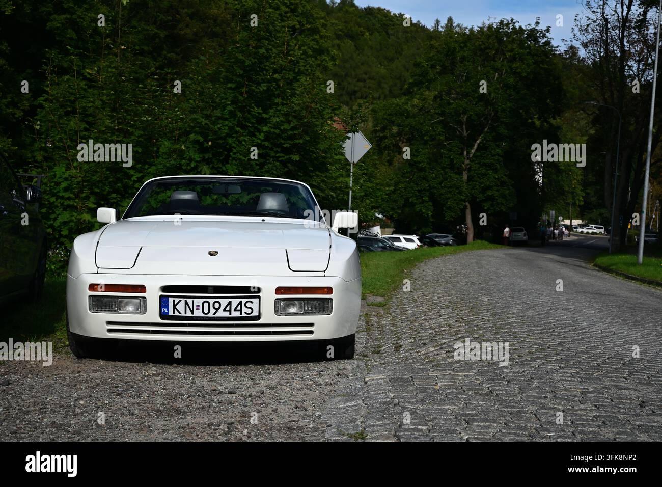 Un classico cabriolet bianco Porsche 944 S parcheggiato su una strada acciottolata, la combinazione unica del numero di targa che fa direttamente riferimento al modello di auto Foto Stock