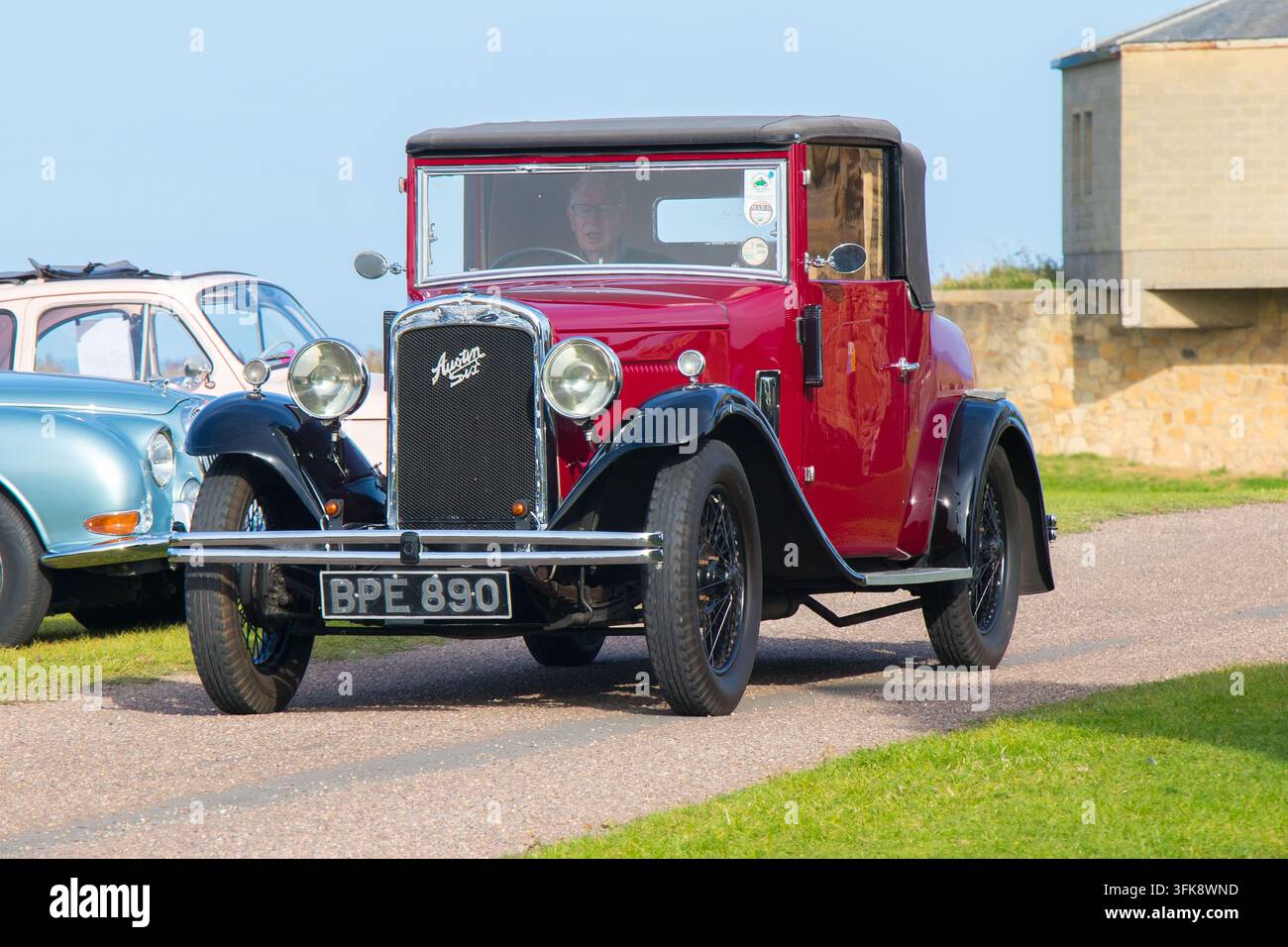 Coupé Austin Seven rosso che procede su un sentiero durante un evento di esposizione di veicoli al Tynemouth Priory and Castle Foto Stock