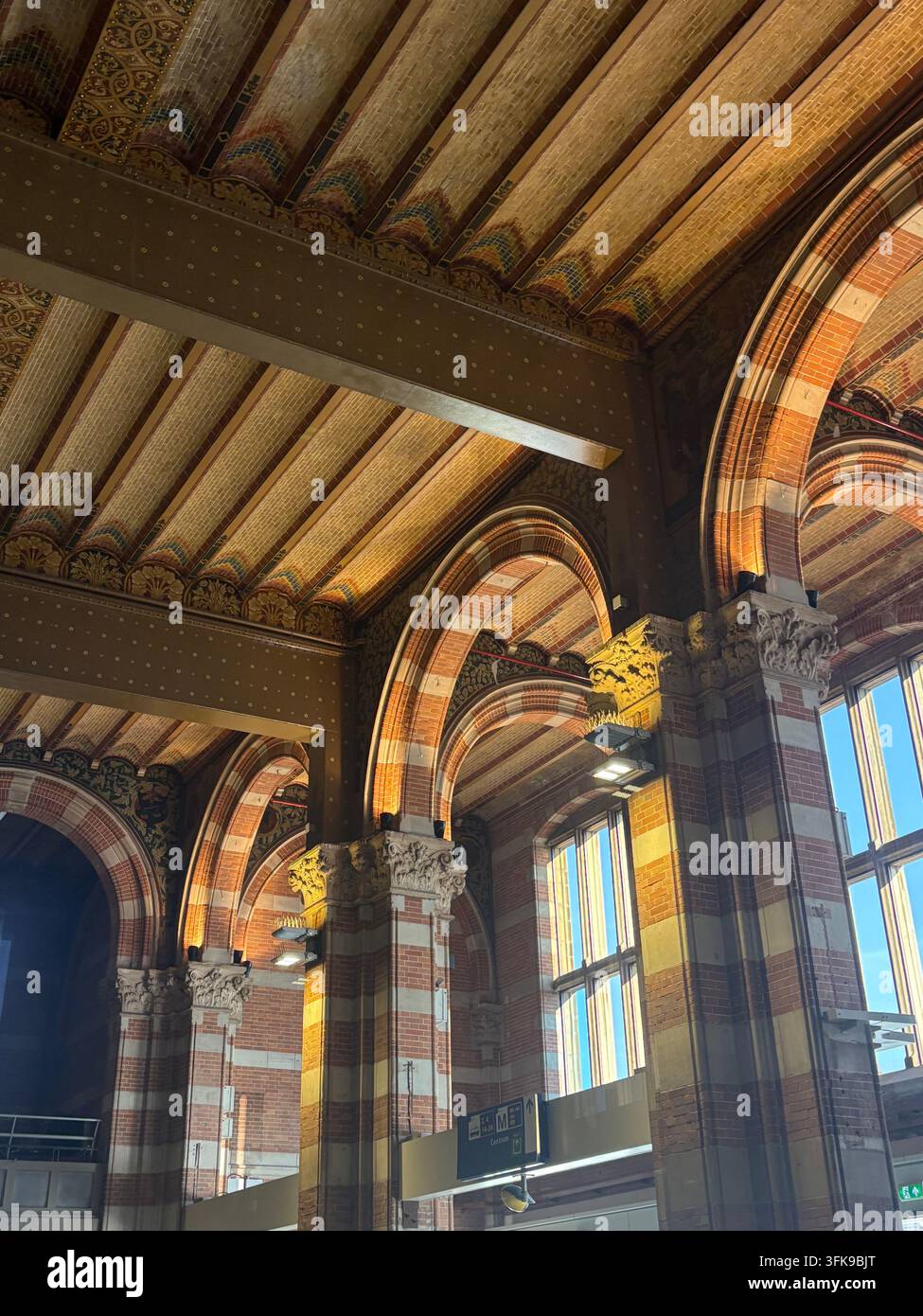 Vista interna della stazione centrale di Amsterdam (Amsterdam Centraal) ad Amsterdam, Paesi Bassi, che mostra il suo design architettonico storico con archi in mattoni decorati. - Immagine stock catturata con smartphone