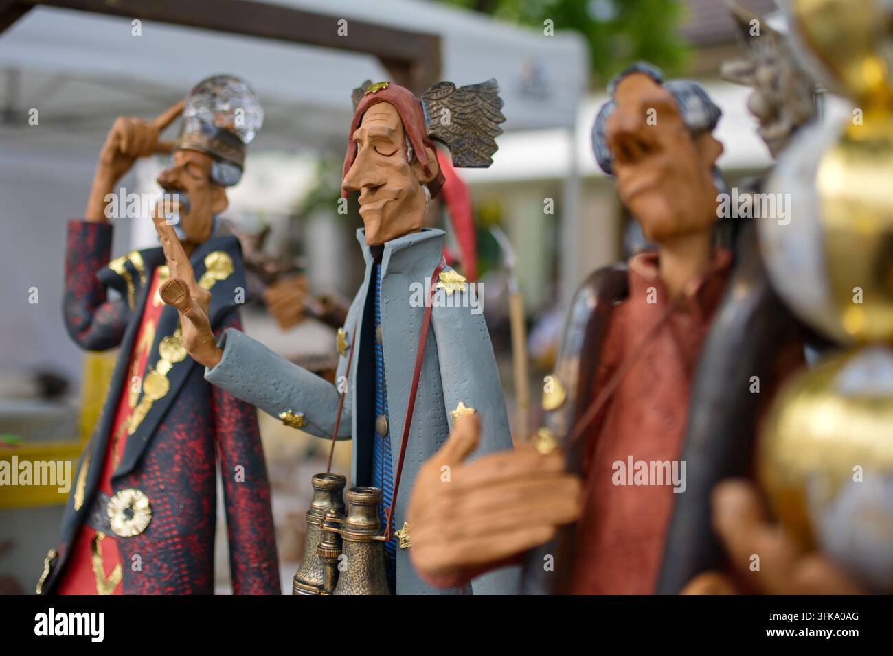 Figure artistiche fatte a mano e statue decorative di personaggi in mostra a un mercato artigianale all'aperto Foto Stock