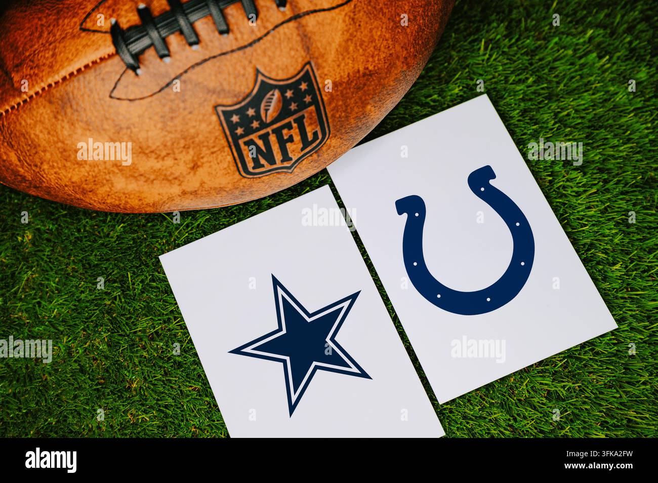TEXAS, USA, 7 SETTEMBRE 2026: Concept di partita NFL Dallas Cowboys vs Indianapolis Colts con loghi delle squadre stampati su carta bianca accanto a una pelle fo Foto Stock