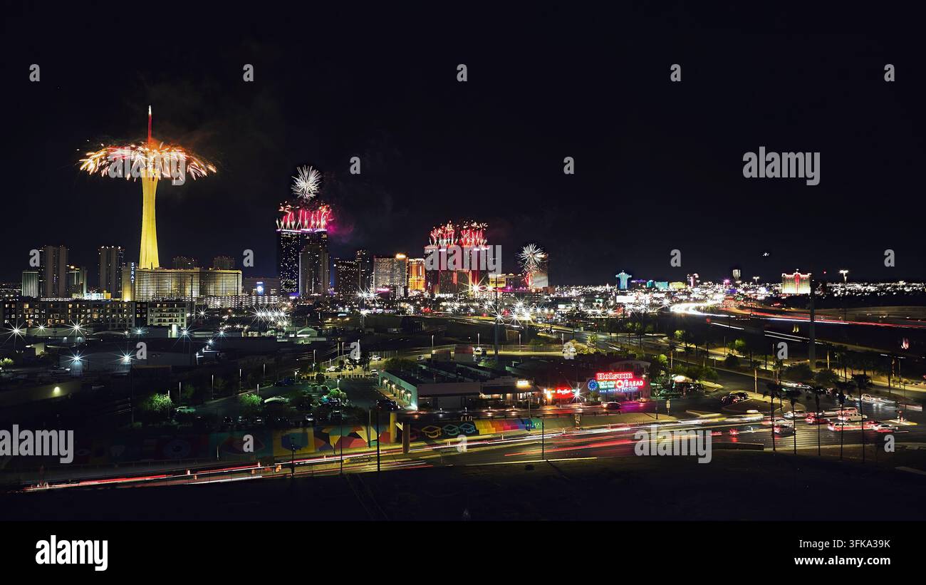 Veduta aerea vibrante del Las Vegas Strip di notte con fuochi d'artificio che illuminano il cielo per il 4 luglio. Le luci al neon della città dello Stratosphere Tower Foto Stock