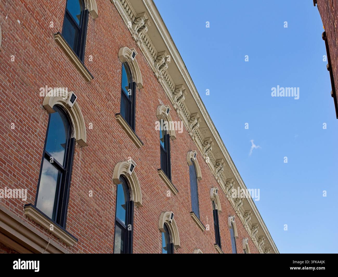 Edificio commerciale in mattoni di stile italianizzato ornato della fine del XIX secolo contro un cielo blu Foto Stock