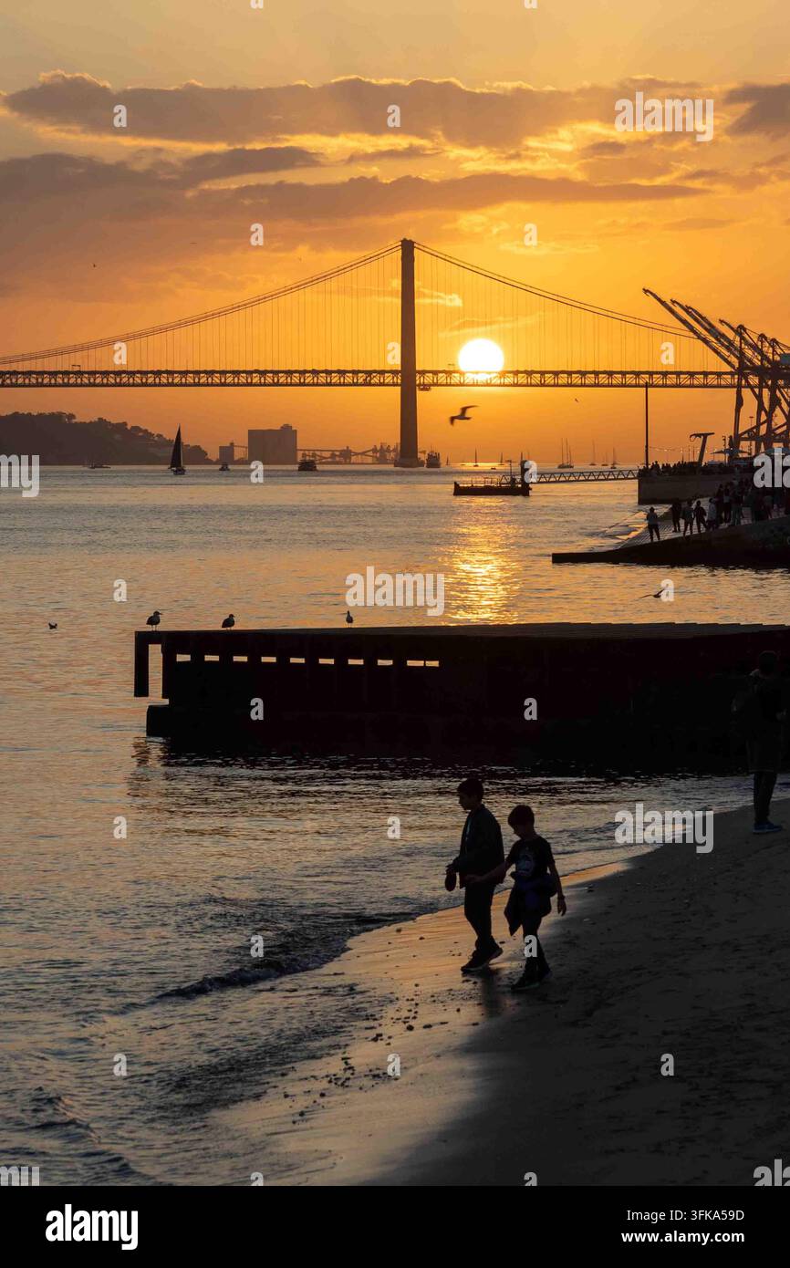 Bambini che giocano durante il tramonto sul Tago a Lisbona in Portogallo Foto Stock