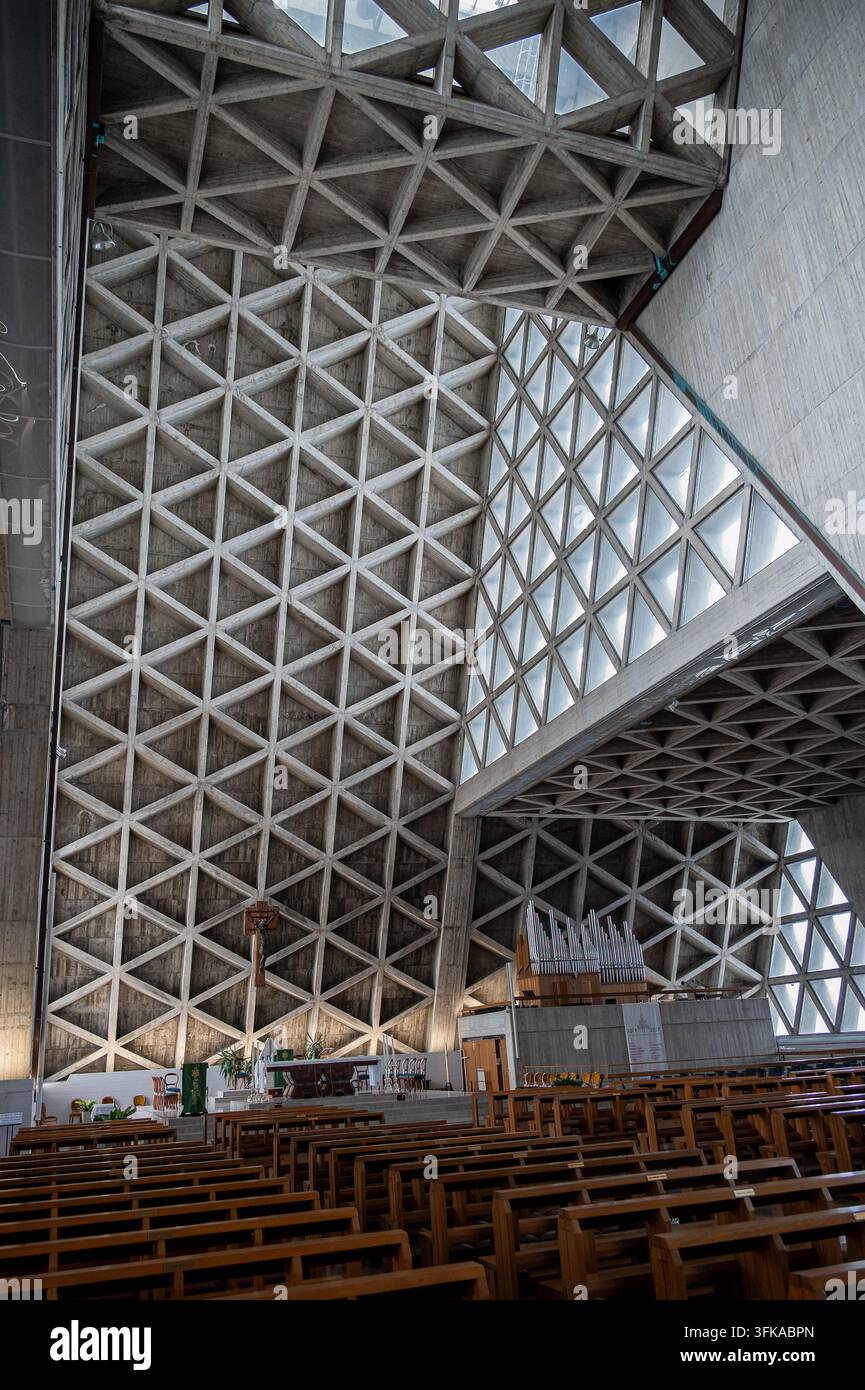 Griglia geometrica in cemento e finestre triangolari all'interno di un interno moderno di chiesa Foto Stock