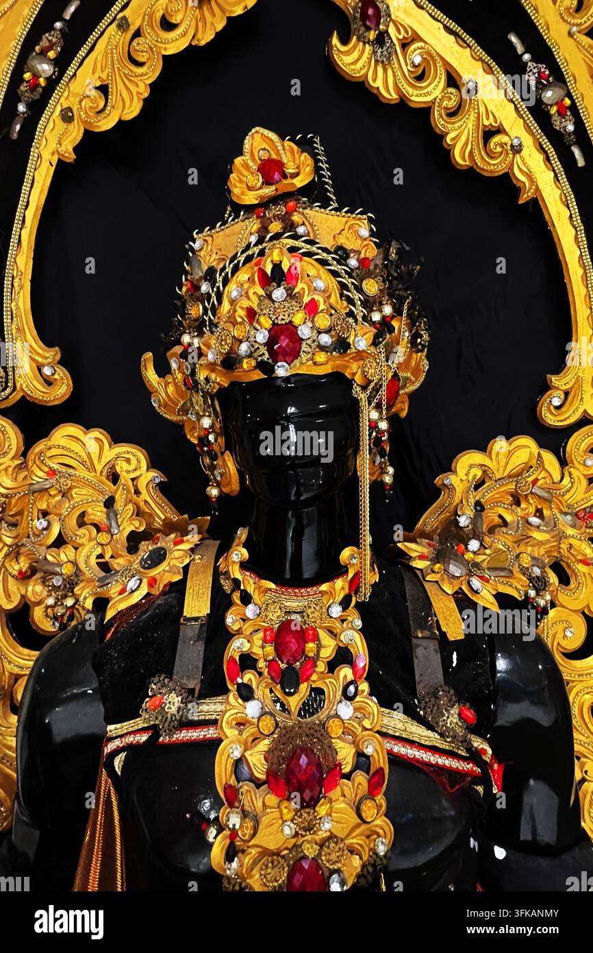 Costume cerimoniale balinese tradizionale con copricapo d'oro elaborato e accessori decorativi, 19 aprile 2026. Foto Stock