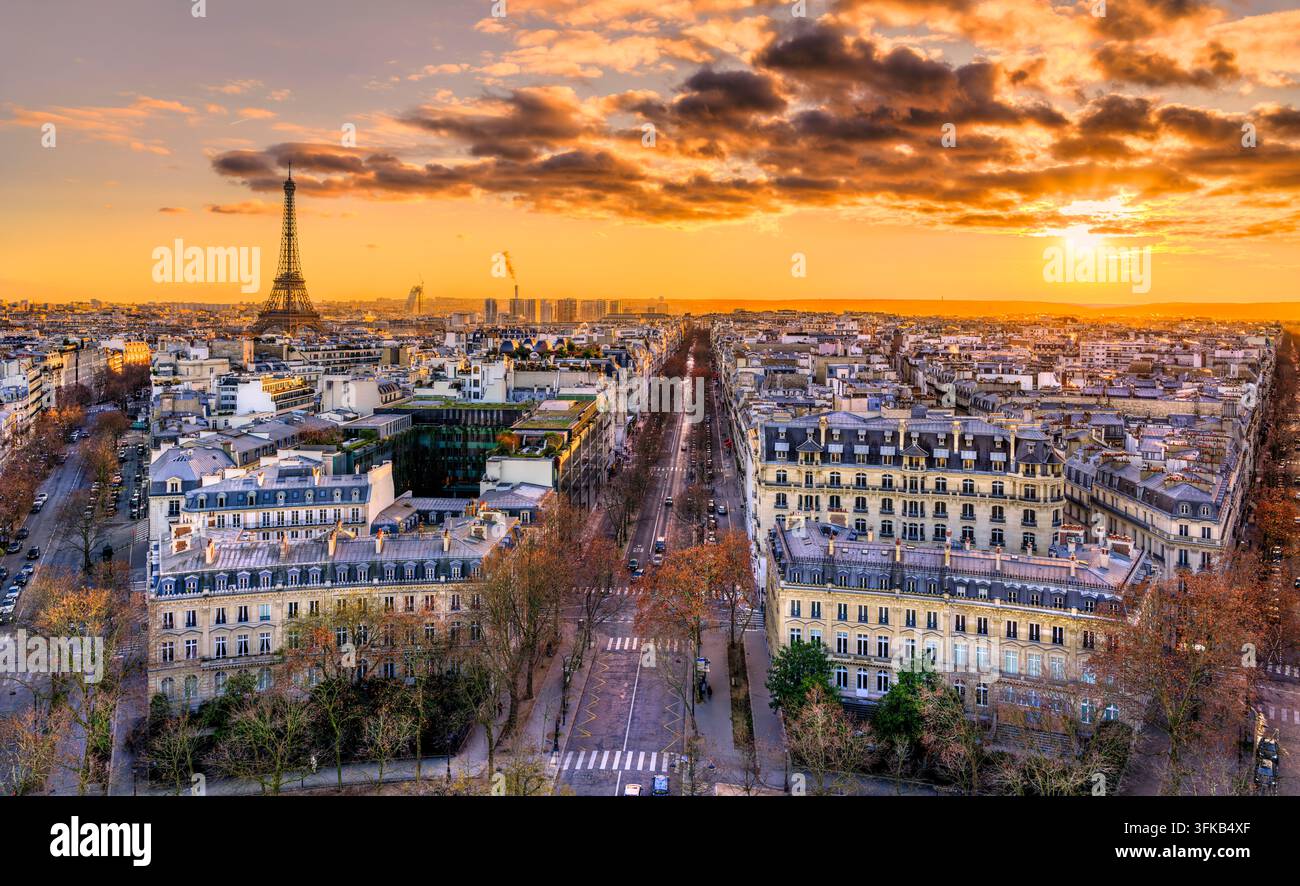 Vista panoramica elevata sull'architettura di Parigi e sulla Torre Eiffel illuminata da un cielo dorato al tramonto. Foto Stock