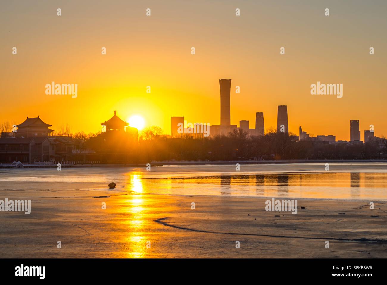 Tramonto sul lago Shichahai ghiacciato in inverno, a Pechino, che unisce paesaggi antichi e moderni Foto Stock