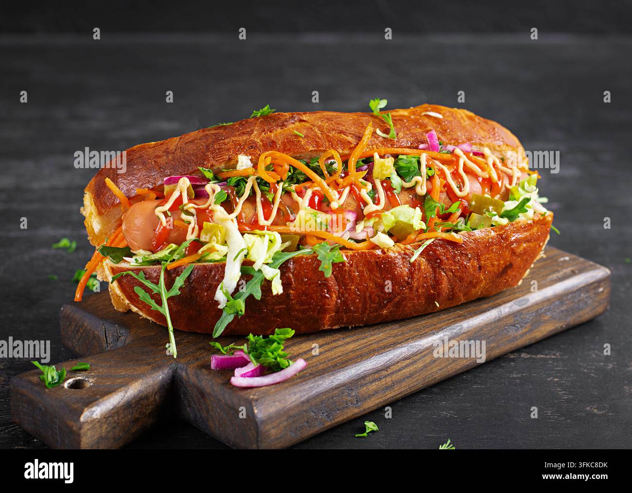 Hot dog premium con ingredienti freschi su tavolo scuro Foto Stock