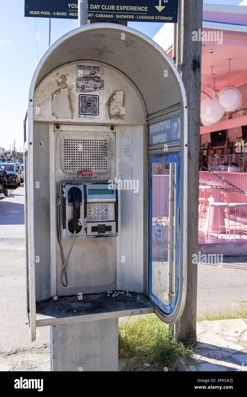 Laganas, Zante Grecia, 1 settembre 2026: Cabina telefonica pubblica erosa contenente un vecchio tastierino per telefoni a gettoni e superfici consumate b Foto Stock