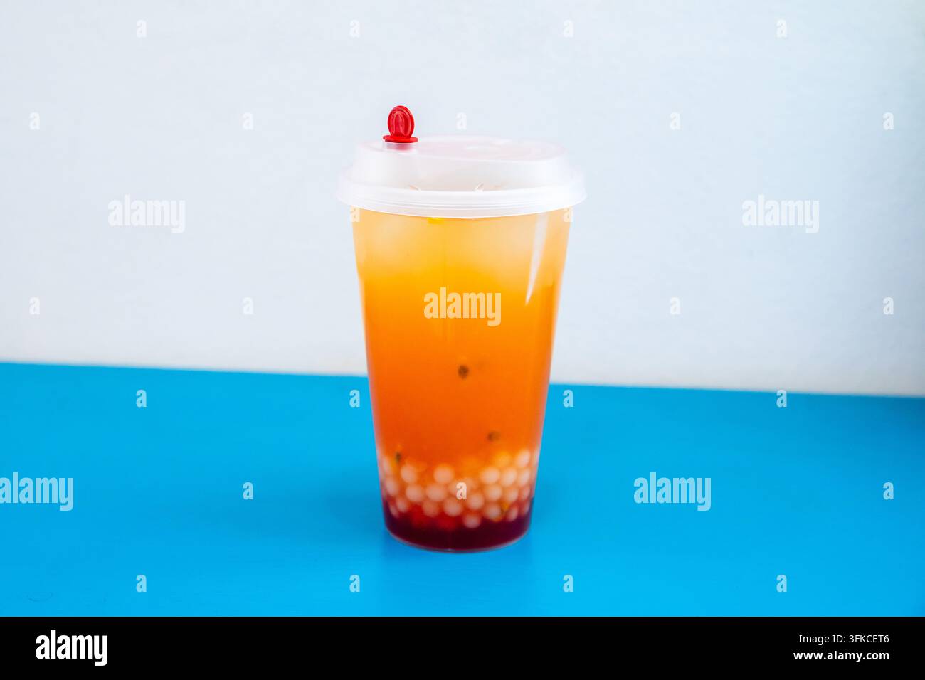 Tè ai frutti con perle di boba in un bicchiere di plastica. Bevanda tropicale rinfrescante con frutto della passione e palline di tapioca. Bevanda estiva per menu da asporto o caffè Foto Stock