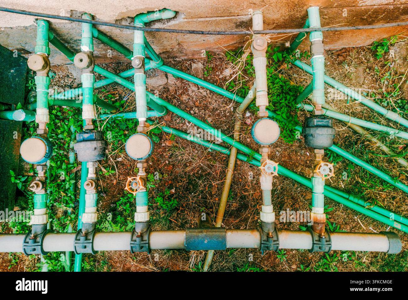 Contatori dell'acqua esterni e tubi di plastica verde PVC a Nairobi, Kenya Foto Stock
