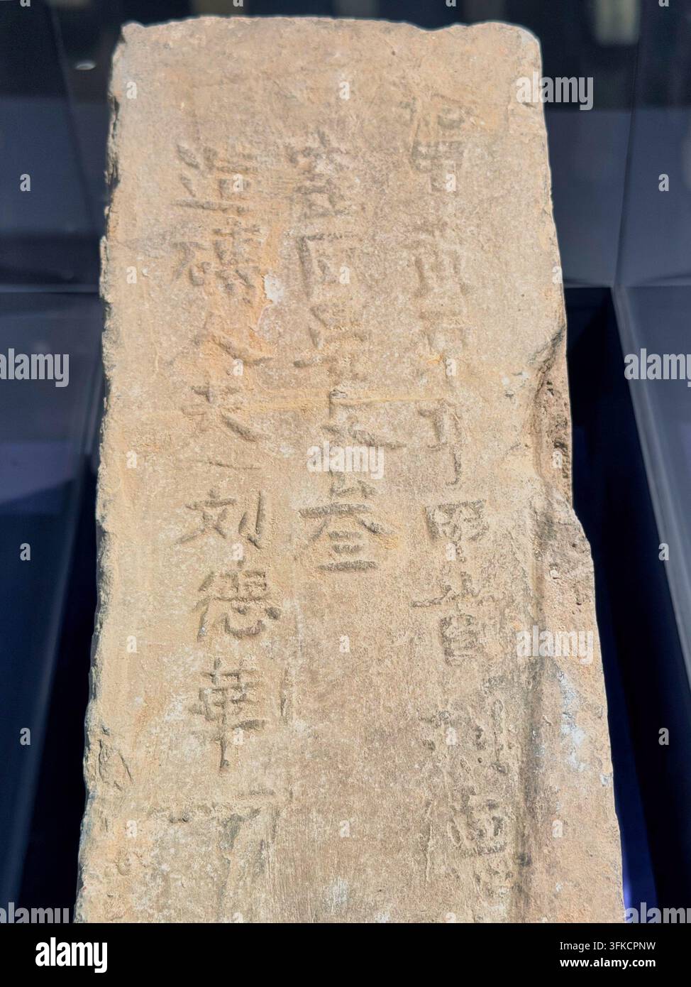 Nanjing, Cina - 24 settembre 2026: Vista ravvicinata di una lastra di pietra erosa con incisioni appena visibili su uno sfondo scuro Foto Stock