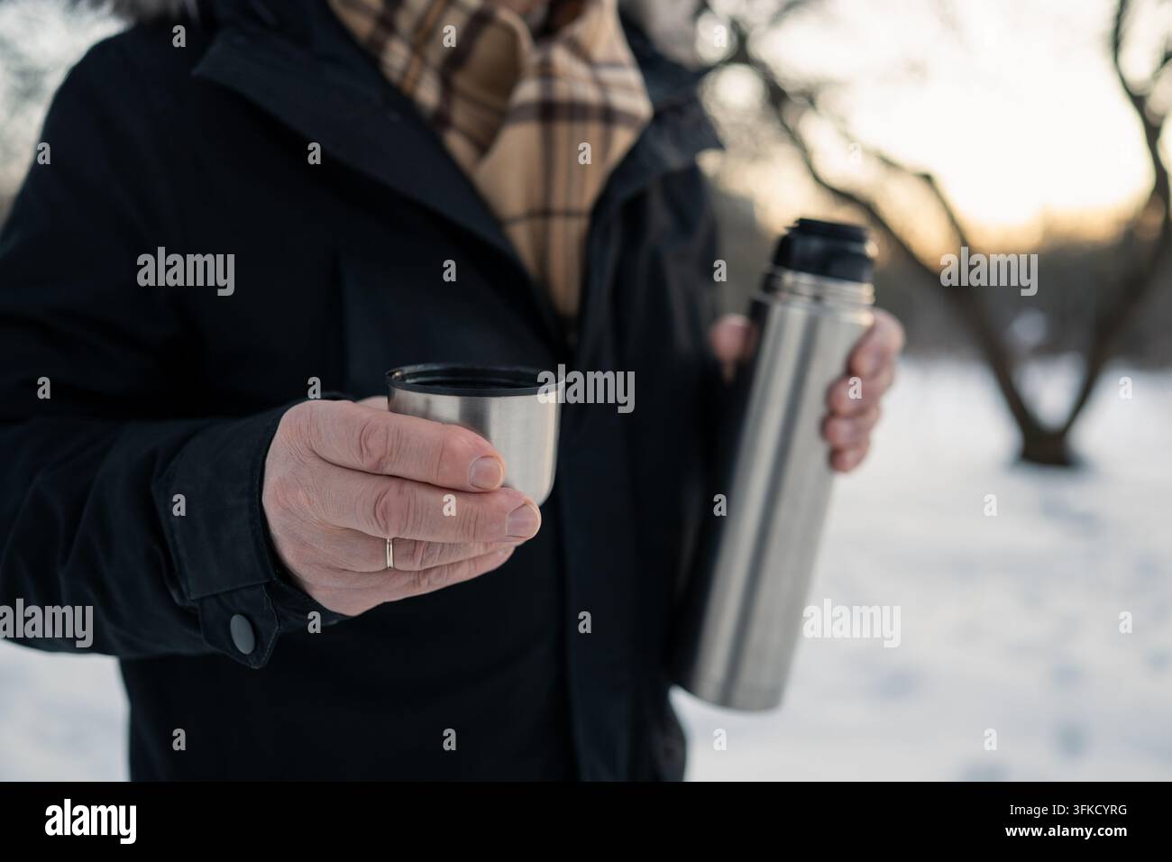 Bevanda calda in tazza termica all'aperto in inverno Foto Stock