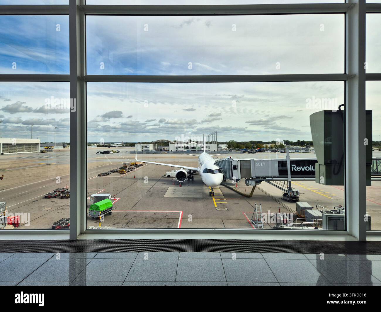 MONACO DI BAVIERA, GERMANIA - 21 SETTEMBRE 2026: Aereo passeggeri commerciale ormeggiato a un gate con una passerella di imbarco sulla pista dell'aeroporto di Monaco di Baviera, visto dall'interno Foto Stock
