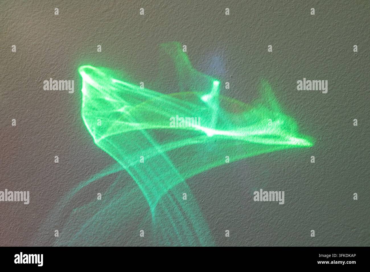 Tratta di luce astratta verde su muro ruvido che crea modelli di movimento ed energia futuristici Foto Stock