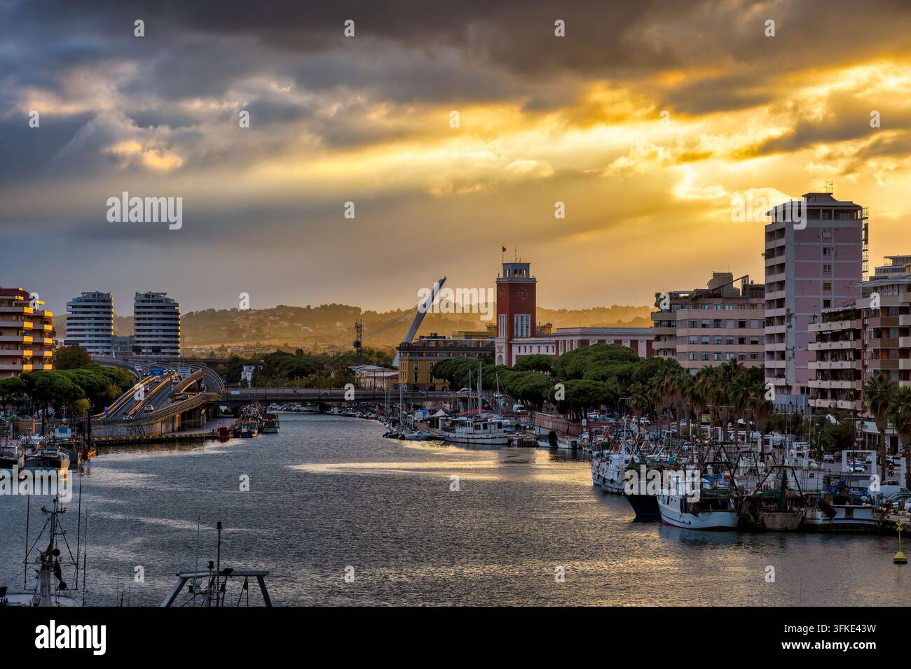 Porto di Pescara con barche da pesca e skyline della città al tramonto a Pescara, Italia Foto Stock