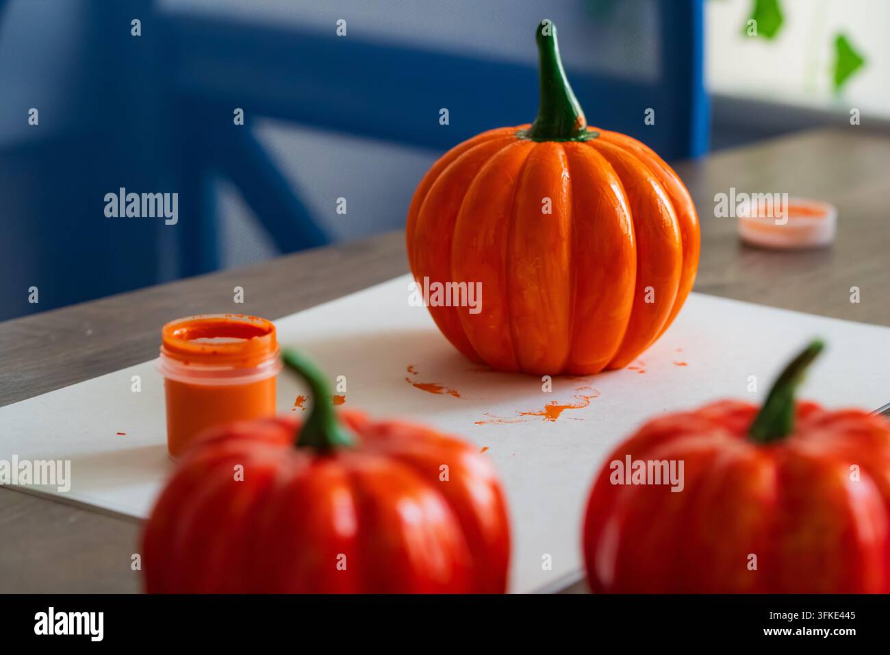 Zucca dipinte a mano per Halloween. Decorazioni artigianali autunnali fai-da-te su un tavolo di legno. Idea creativa per decorare le feste autunnali. Foto Stock
