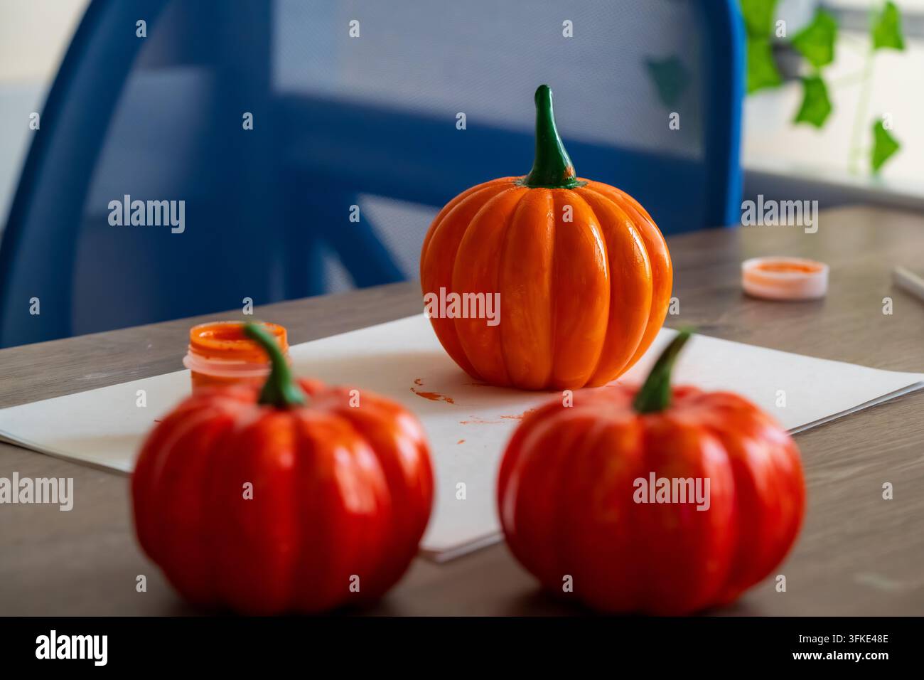 Zucca dipinte a mano per Halloween. Decorazioni artigianali autunnali fai-da-te su un tavolo di legno. Idea creativa per decorare le feste autunnali. Foto Stock