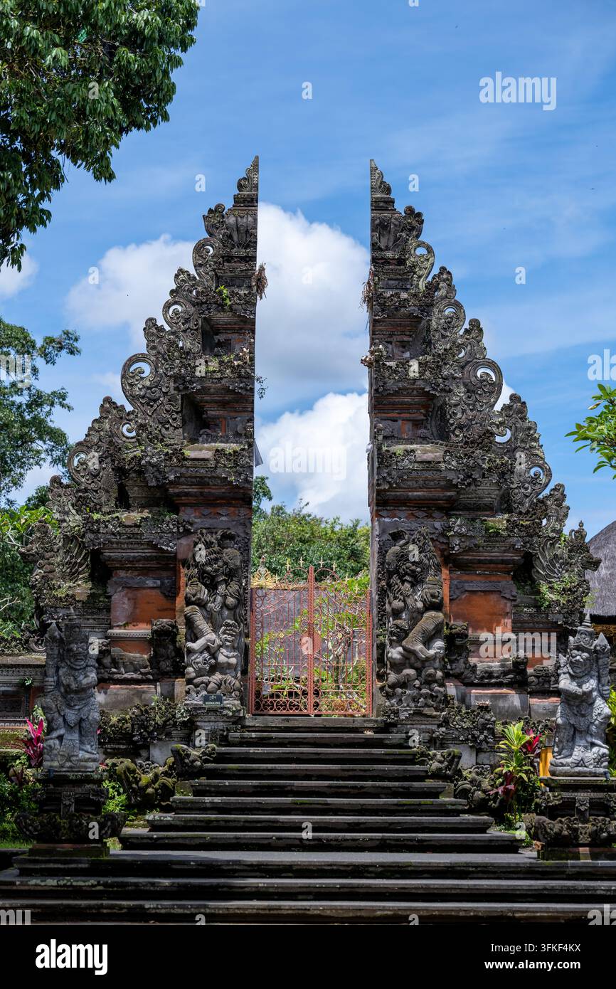 Ubud, Bali, Indonesia, 18 marzo 2026. Un elaborato cancello diviso con figure di guardiani intagliati segna l'ingresso di un complesso tradizionale a Ubud. Foto Stock