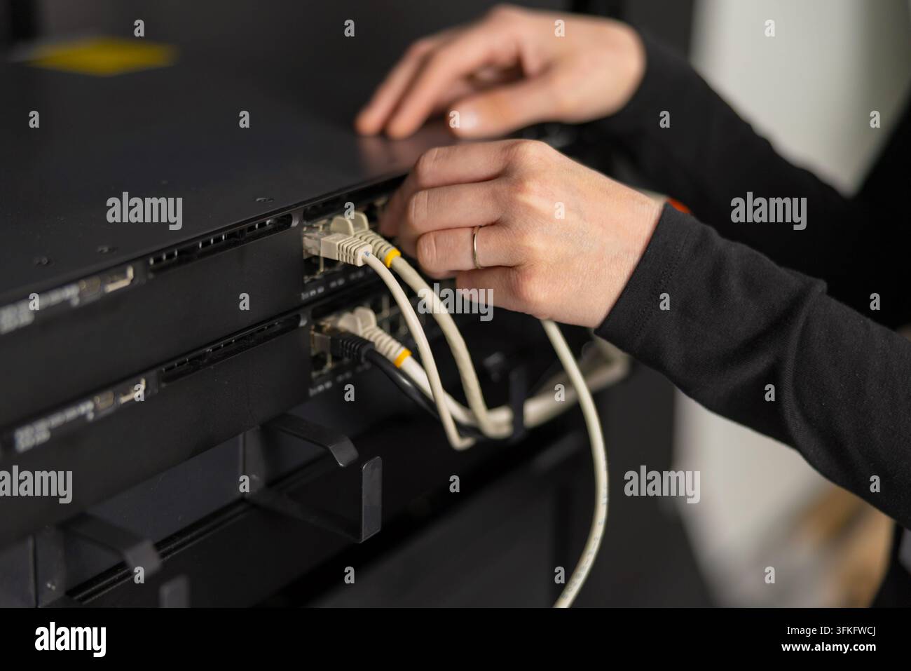 Tecnico informatico adulto mantiene le apparecchiature di rete collegando e configurando server in un data center Foto Stock