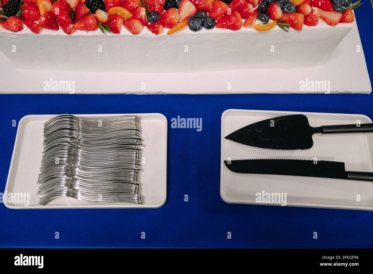 Torta di frutta e utensili da servizio a una celebrazione Foto Stock