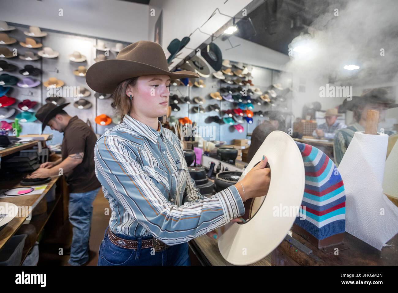 Greeley, Colorado – Greeley Hat Works, un'azienda centenaria, produce migliaia di cappelli western ogni anno. Un operaio utilizza il vapore per ottenere la forma corretta Foto Stock